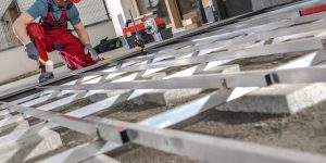 Caucasian Construction Worker Building Composite Boards Residential Patio Area Based on Aluminium Frame